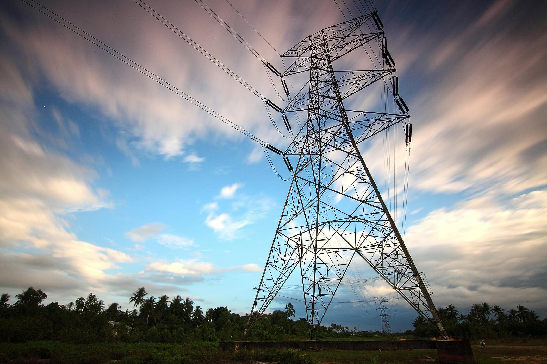 An electricity pylon against a dramatic sky at sunset.