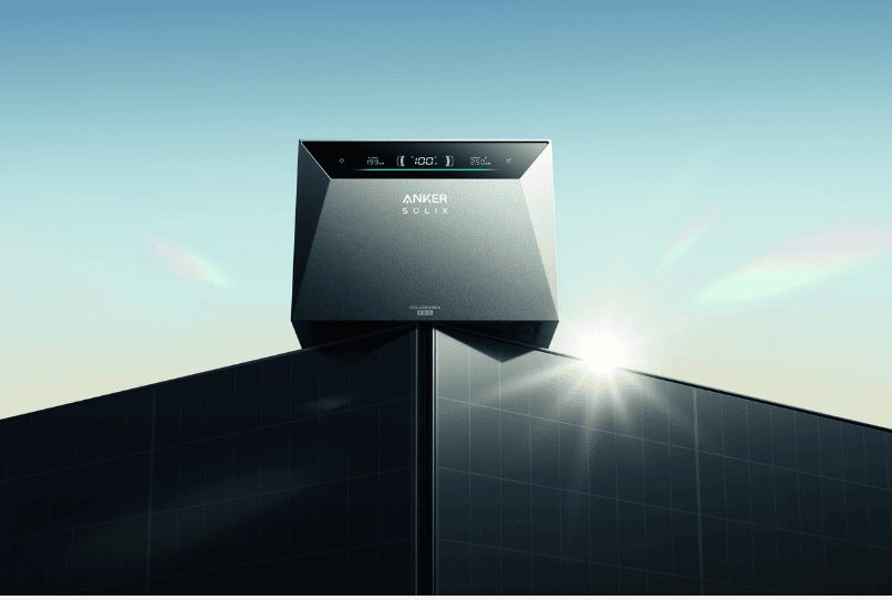 A black Anker plug-in solar battery unit lit by the sun against a clear sky.